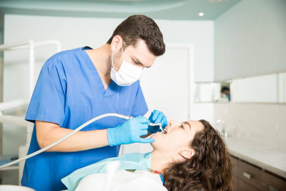 a woman receiving dental cleaning from a professional dentist