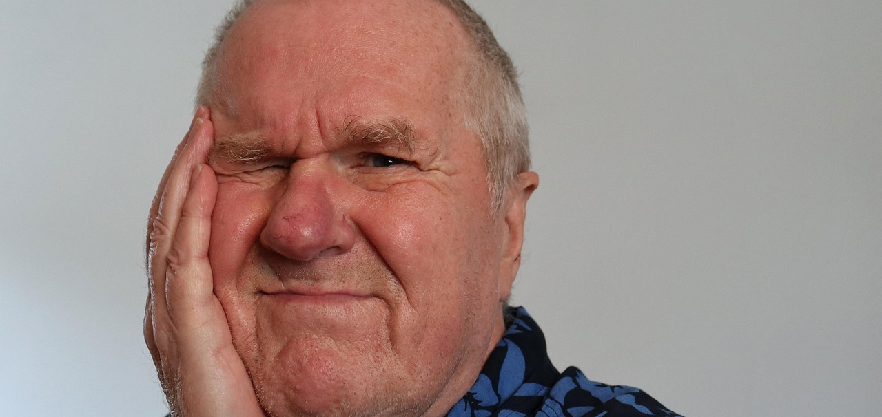 an old man having tooth ache