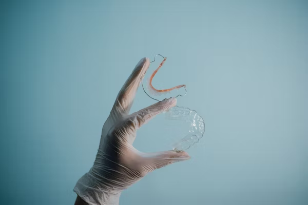 a hand holding up a pair of mouth guards
